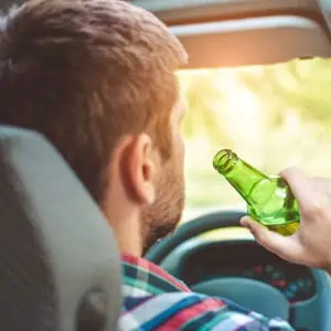 A man is sitting in a car drinking alcohol - Darryl A. Stallworth Law Office